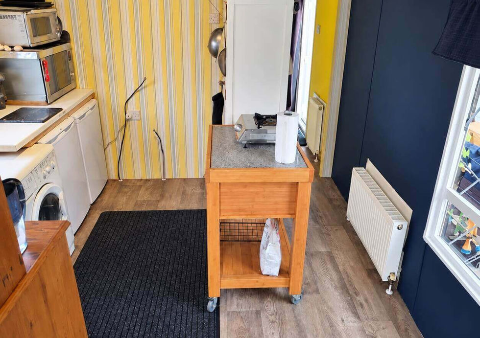 Practical fitted kitchen and utility area inside Peggy Rose floating home.