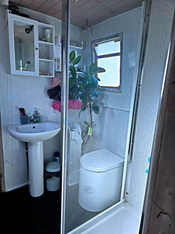 Compact bathroom with sink, toilet, and shower