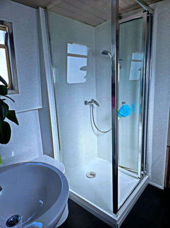 Bathroom with glass shower cabin and white sink