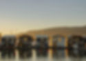 Floating homes on water at sunset with mountains