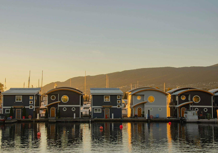 Floating homes on water at sunset with mountains