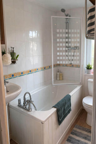 Bathroom with white tub, sink, and shower screen