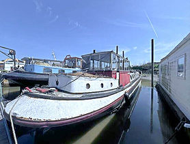 White and red houseboat docked in a canal