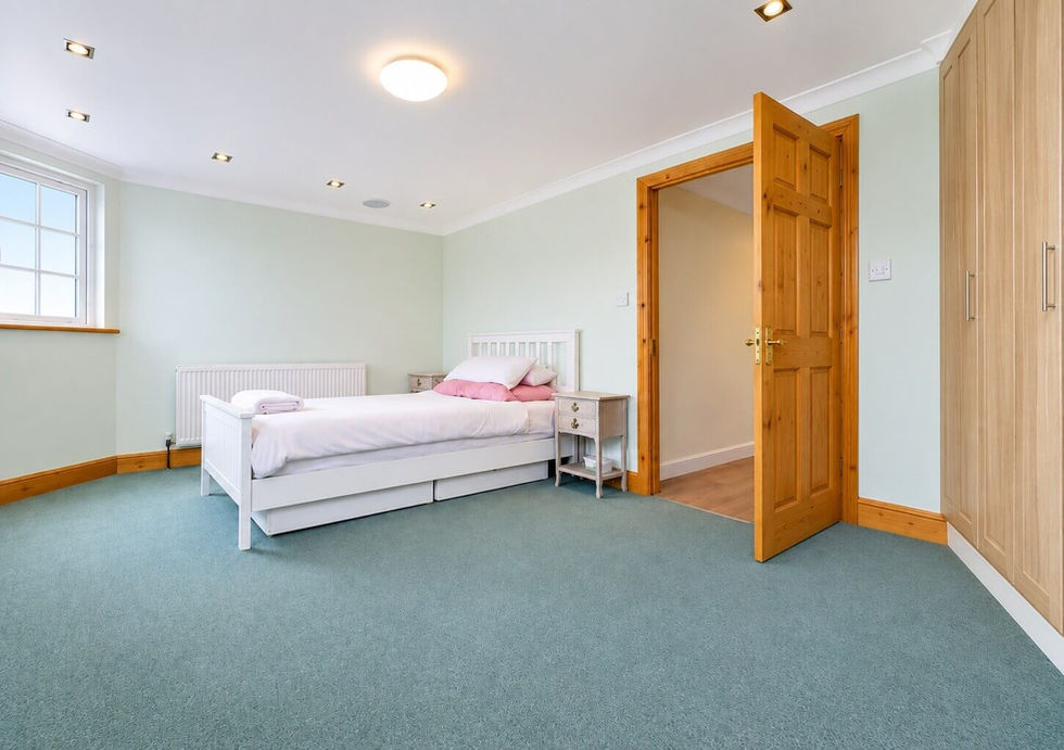 Bright bedroom aboard Perch houseboat with fitted wardrobes and large window.