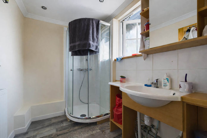 Bathroom with corner shower and sink