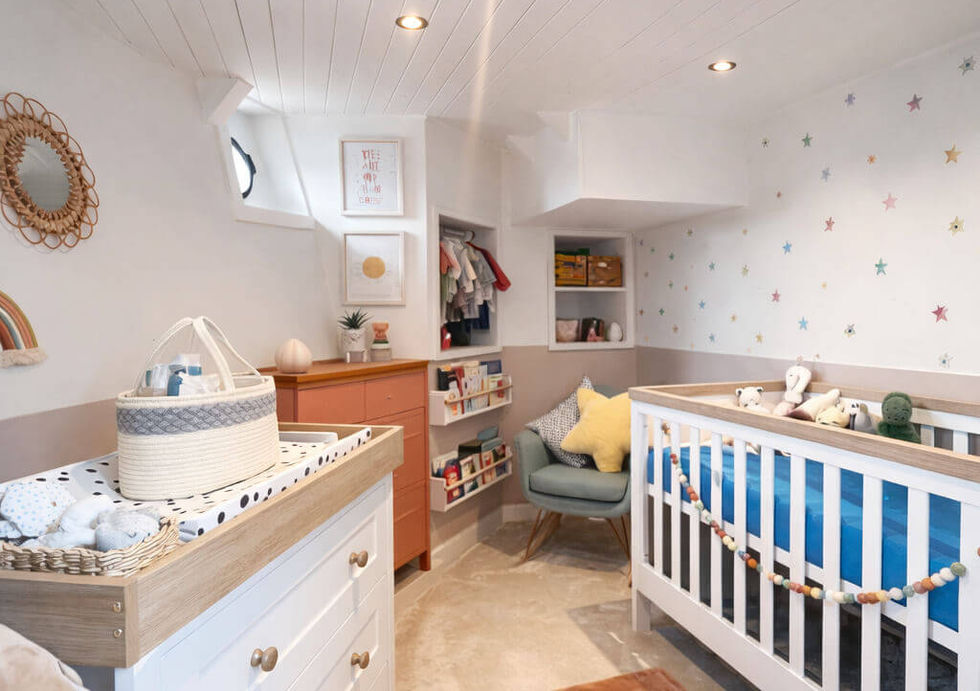 A cozy baby's room featuring a crib, a changing table, and a dresser, all arranged for comfort and functionality.  