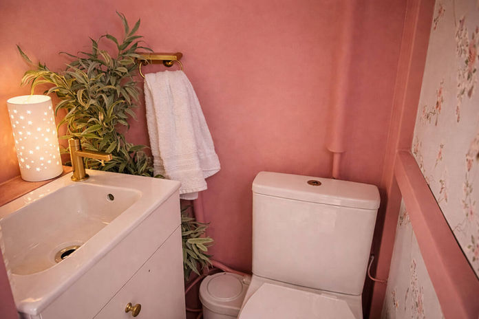 Pink bathroom with white toilet and sink