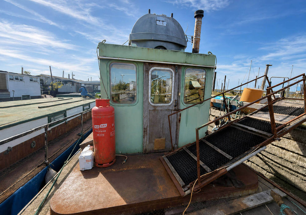 Wheelhouse exterior of project houseboat with access stairs and working deck.