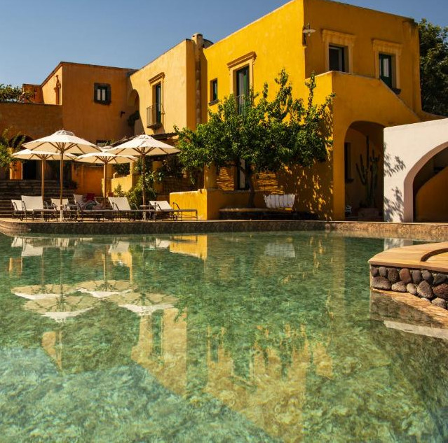 Outdoor pool and yellow buildings at the accommodation.