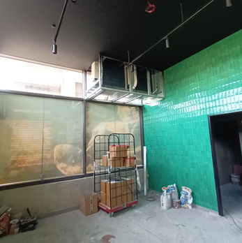 Intérieur d'un local commercial vide avec des murs verts et un plafond noir.