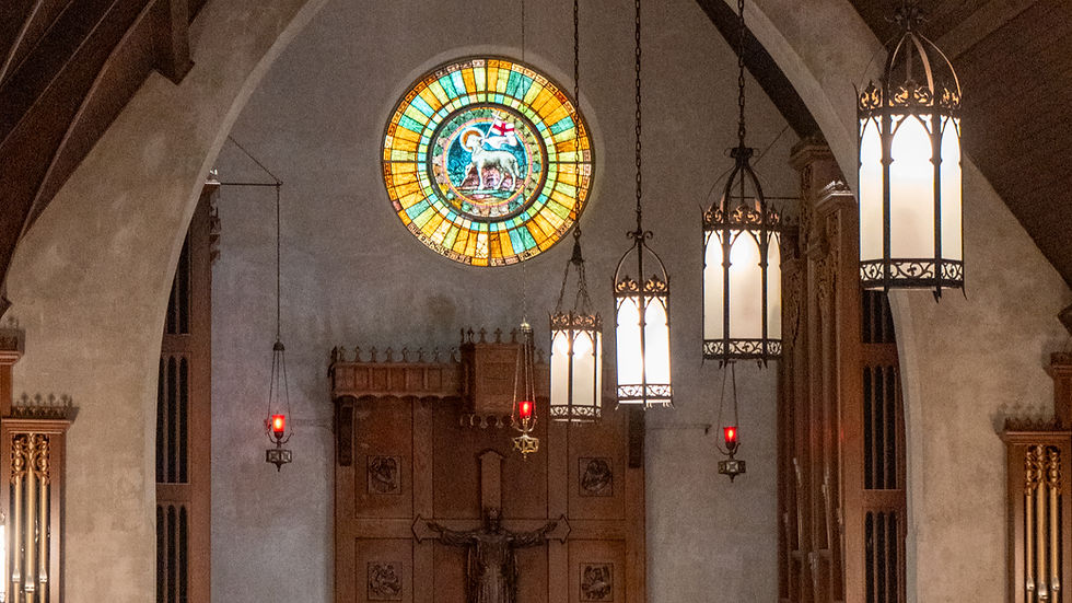 Interior of St. Paul’s Episcopal Church, with a row of hanging lights leading toward a circular stained-glass window.