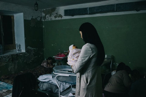 A woman with a child standing in a room