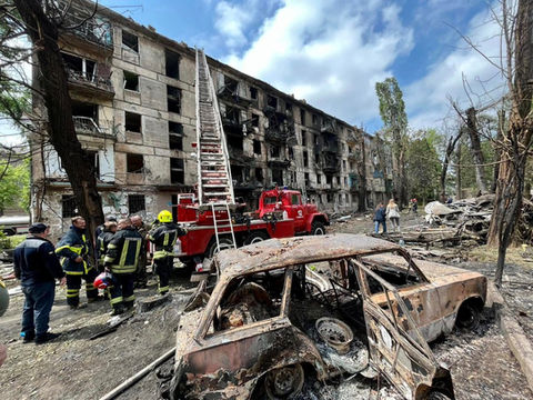 A burned out building with a fireman standing next to it