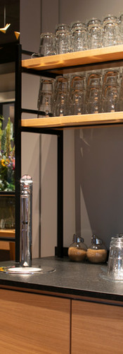 Hinsche GastroDesign – Offene Servicestation mit schwarzem Metallregal, Kiefernholzböden und Glasbestückung im Gastronomiebetrieb