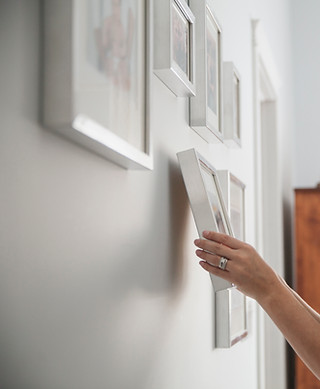 Woman Hanging Framed Photos