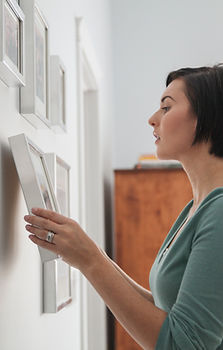 Woman Hanging Framed Photos