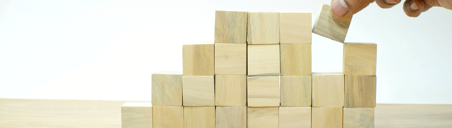 Hand arranging wood block stacking as st
