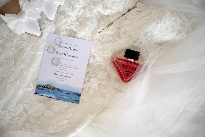 Wedding invitation with Lauren & Cian's names, Prada perfume, and beautiful lace detail.