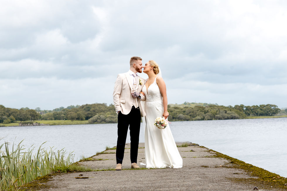 Bride and groom kiss on pier near water, Nichola and Chris, White Amber Photography – Cork Wedding