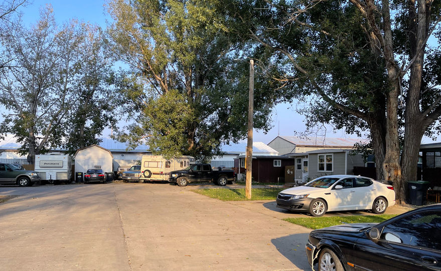 Street view of mobile homes at Countryside MHC in Mandan, ND with well-maintained homes and paved roads