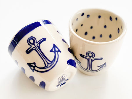 two ceramic cups with a dark blue anchor on the front