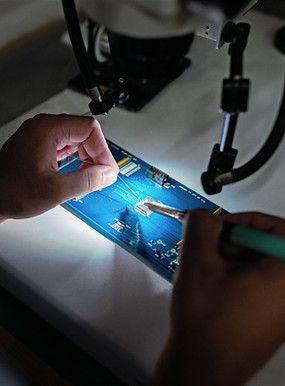 Male broadcast engineer solders circuit 