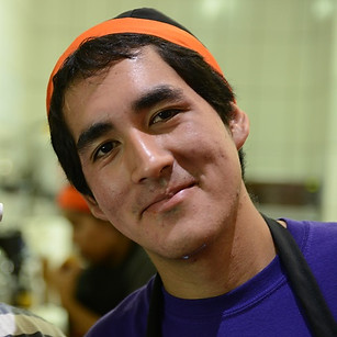 Young man wearing an apron and a chef's hat