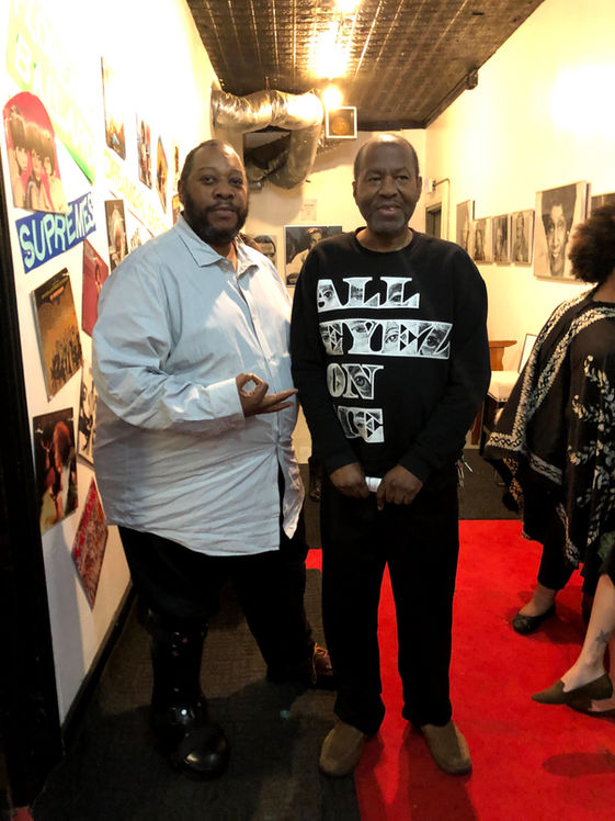 Two men at "Surprise" art gallery event.