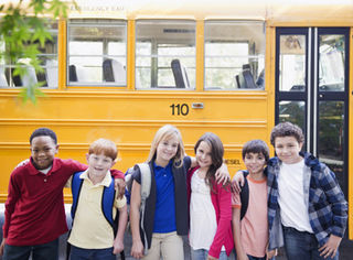 Groupe scolaire en visite pédagogique dans le Jura, enfants attentifs devant une animation scientifique en plein air.