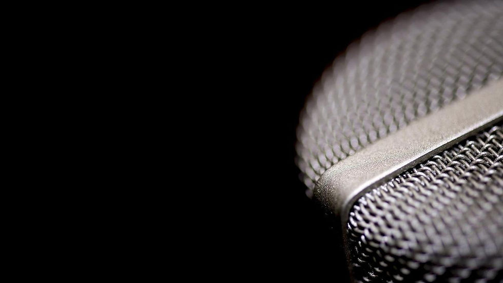 Close-up of a silver microphone grill with a black background. The intricate mesh pattern is highlighted, creating a sleek, modern feel.