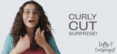 Woman with long brown curly hair is showing wide-eyed surprise with an open mouth and hands.