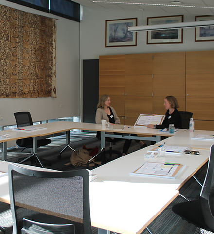 Two people discussing emdr with diagrams in workshop space