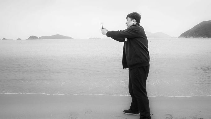 The man who was careful not to get his trainers wet photographing the edge of the beach