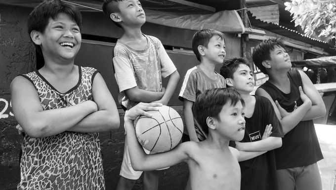 The boy with the basketball with the very long left arm