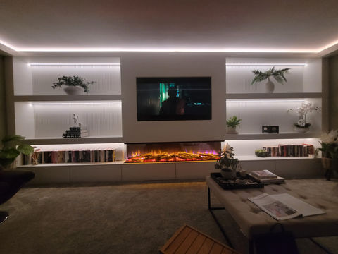 Fantastic Media wall with real flame effect electric fire and lower storage shown at night with recessed LED downlights