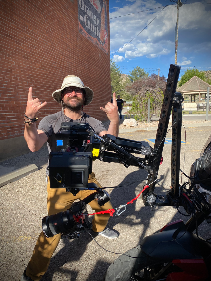 Camera man posing by motorcycle