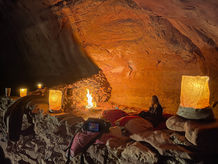A captivating image showcasing the ancient Bedouin caves nestled amidst the breathtaking landscape of Wadi Rum. The caves' rugged exteriors blend harmoniously with the desert surroundings, evoking a sense of mystery and history.