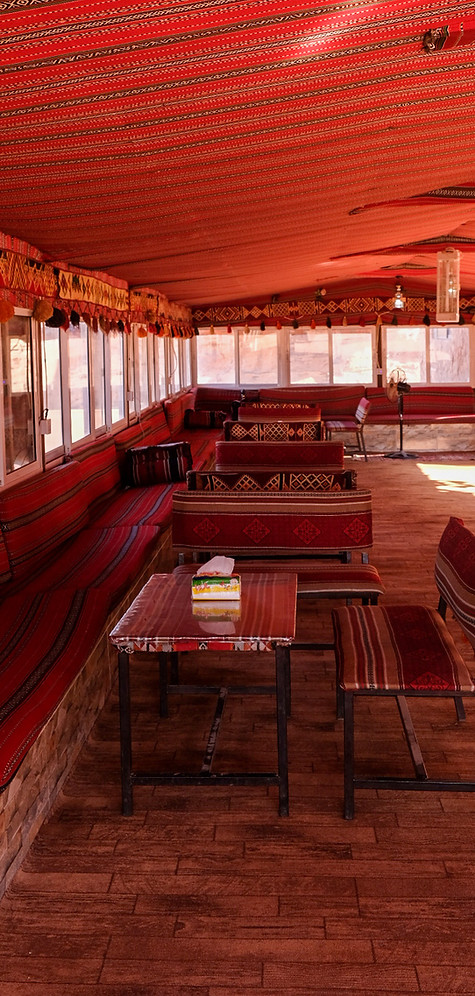 Wadi Rum Bedouin Tents: A captivating image showcasing traditional Bedouin tents set against the stunning backdrop of Wadi Rum's desert landscape, with sand dunes and rocky mountains in the distance.