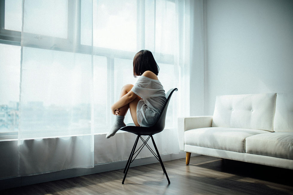 woman by a sunlit window, reflecting — representing shame therapy in the Hills District at Dolphin Tribe.
