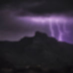 A very dark scene of a fuzzy table mountain in shades of black and gray There is a single