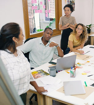 A person at a whiteboard talking to colleagues