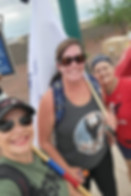 Three West Valley Women Veterans members smiling together while volunteering at an outdoor flag-placement event.