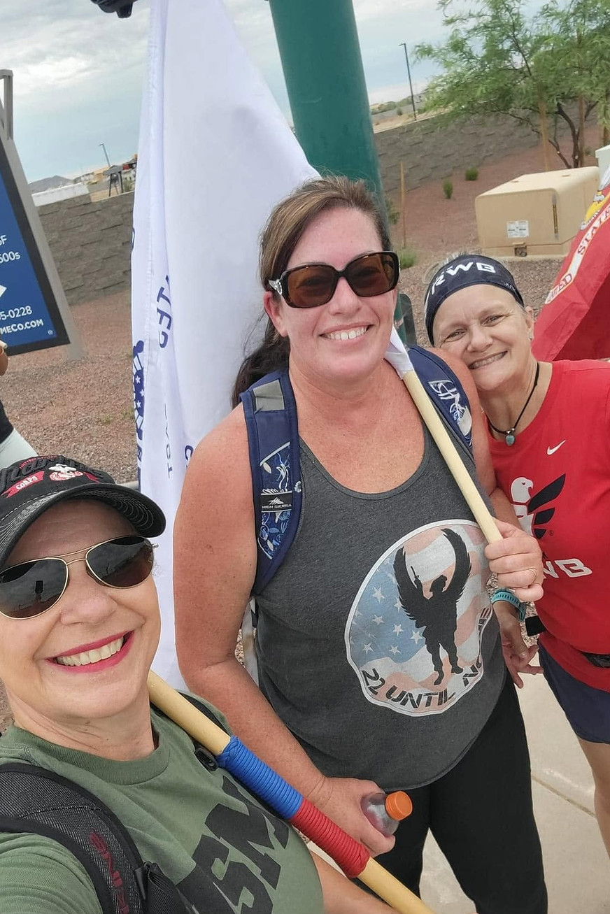 Three West Valley Women Veterans members smiling together while volunteering at an outdoor flag-placement event.