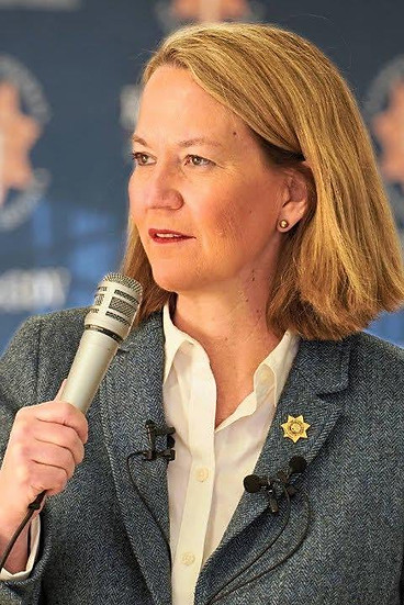Woman speaking into a microphone during a West Valley Women Veterans leadership event.