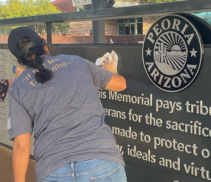 West Valley Women Veterans volunteer cleaning a veterans memorial in Peoria, Arizona.