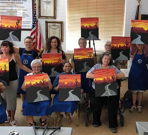 West Valley Women Veterans members displaying desert sunset paintings after a group art class.