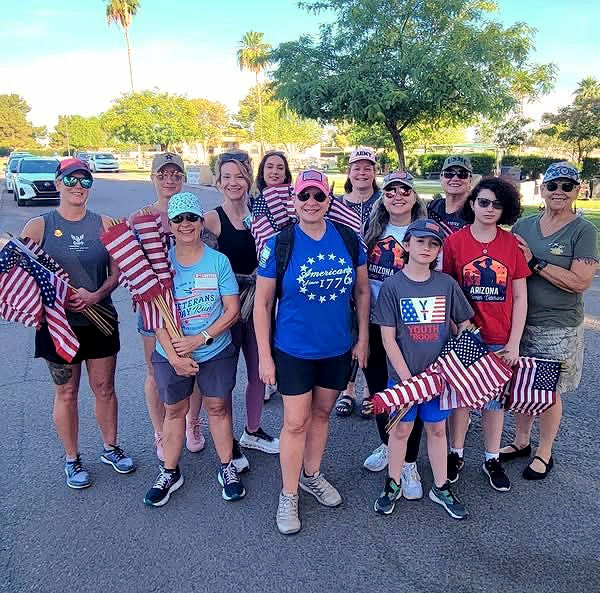 West Valley Women Veterans members and volunteers holding American flags during a community service event in Arizona.