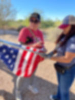 Two West Valley Women Veterans members placing an American flag during a community service event in Arizona.