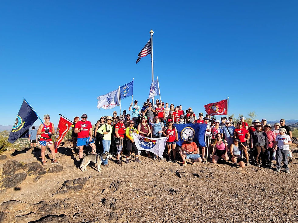 Women veterans and community members gather with American and military service flags after an Arizona group hike.