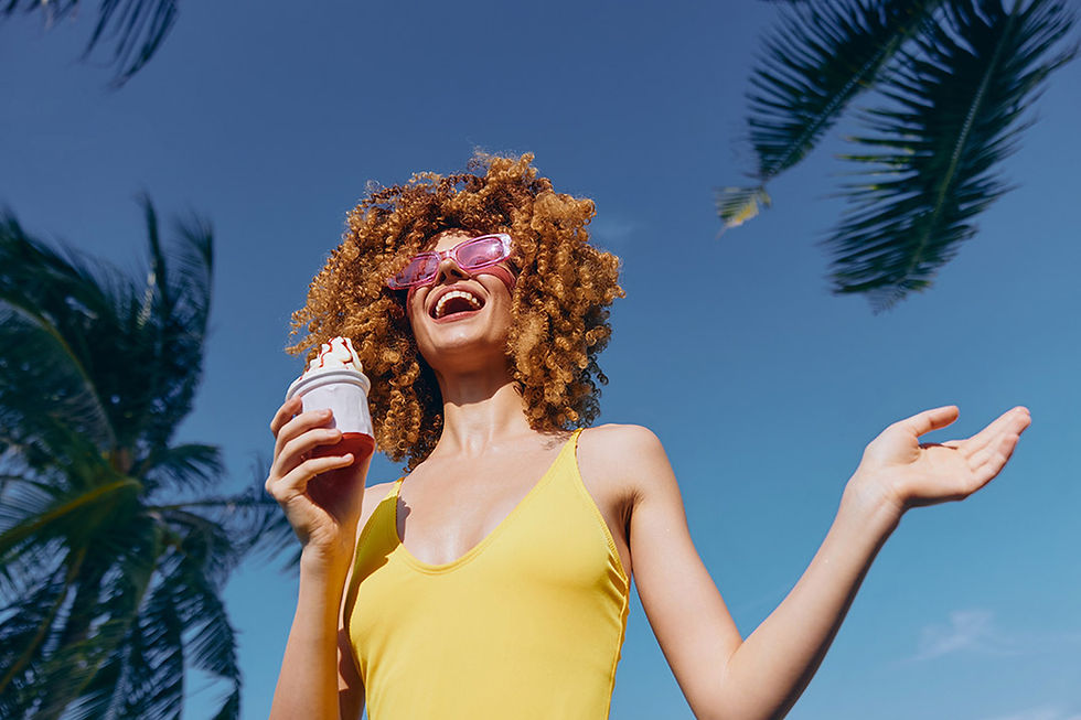 Cheerful woman outside on a beautiful tropical day holding a dessert.